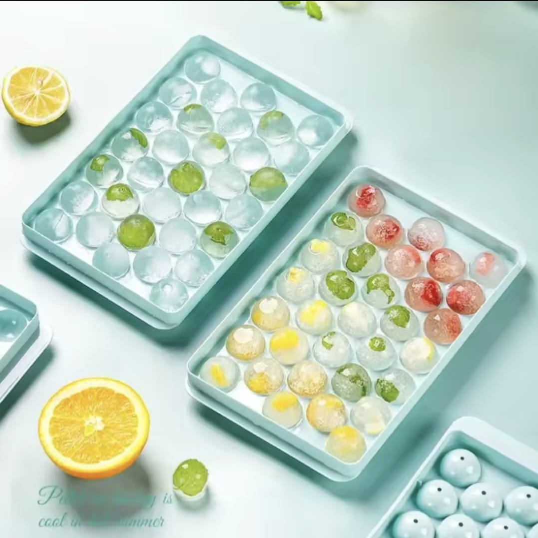 Round 33-grid ice cube tray with lid creating fruit-infused spherical ice balls for drinks.
