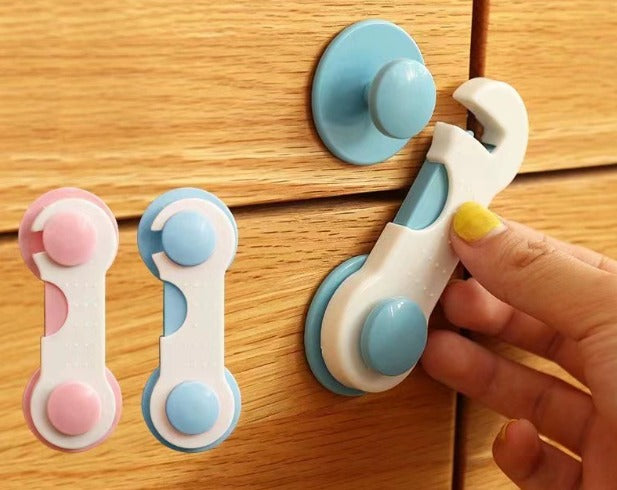 children safety drawer locks in white, blue and pink installed on cabinet and fridge doors for childproof home protection.