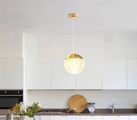 Gemelli Collections gold crystal globe pendant light featuring a textured clear glass sphere, luxury gold metal cap, and elegant ceiling-mounted design for modern and contemporary interiors.