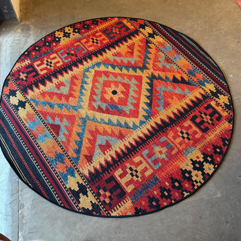 Oriental Weavers Isla round batik tribal geometric rug with red, orange, beige, navy, and blue pattern for indoor and outdoor spaces.