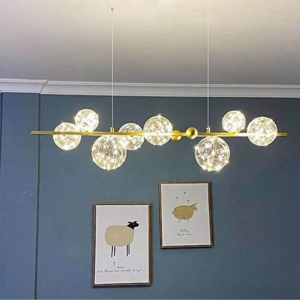 Gemelli Collections 8-bubble linear chandelier featuring crackled glass globes with fairy lights, polished gold bar frame, and luxury ceiling-mounted design for dining rooms and modern interiors.