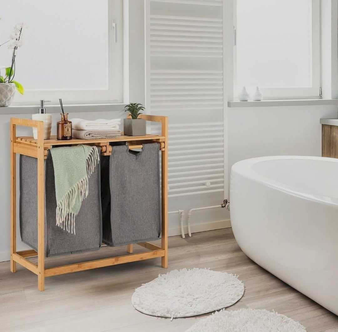 Freestanding bamboo laundry hamper with pull out laundry bags and storage shelf for organising clothes towels and household essentials.