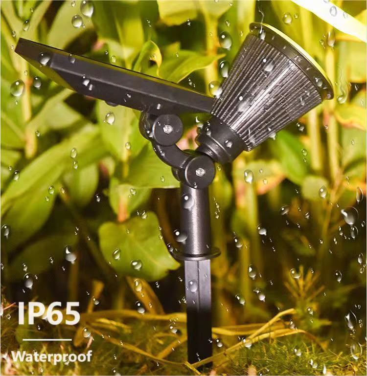 Black IP65 waterproof solar LED garden spotlight with adjustable head, integrated solar panel, and ground stake.