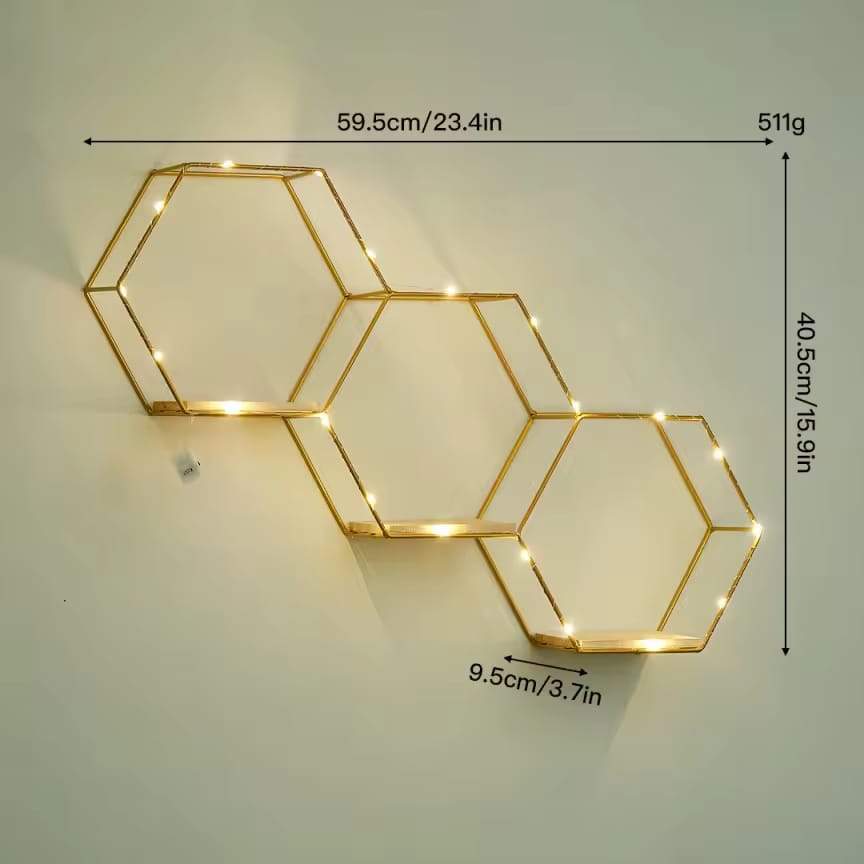 Gemelli Collections gold hexagon wall shelf with natural wood bases and warm LED fairy lights in a geometric honeycomb floating design for decorative home display.