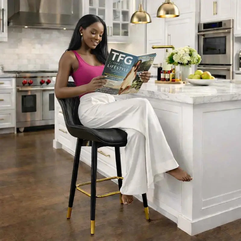 Luxury black PU leather bar stool with diamond quilted backrest, gold footrest, and black metal legs with gold accent caps.