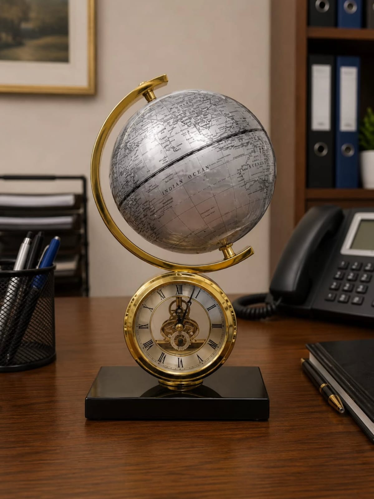 Gemelli Collections Atlasphere table clock featuring a rotating silver world globe, gold skeleton clock with Roman numerals, and black marble base for executive office décor.