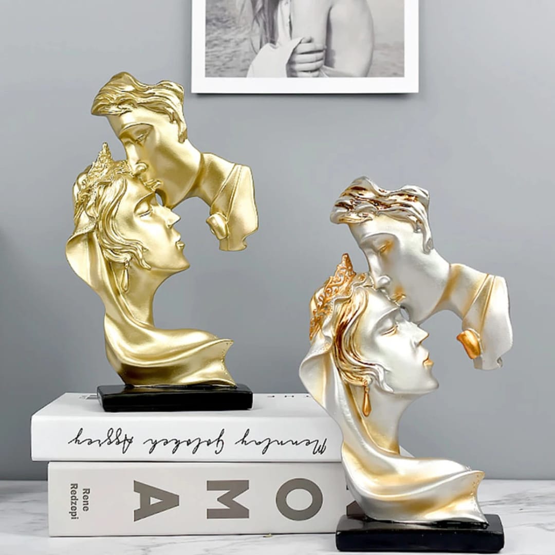 Gemelli Collections romantic couple statue featuring a forehead kiss design on a black base, available in classic gold and silver with gold accents.