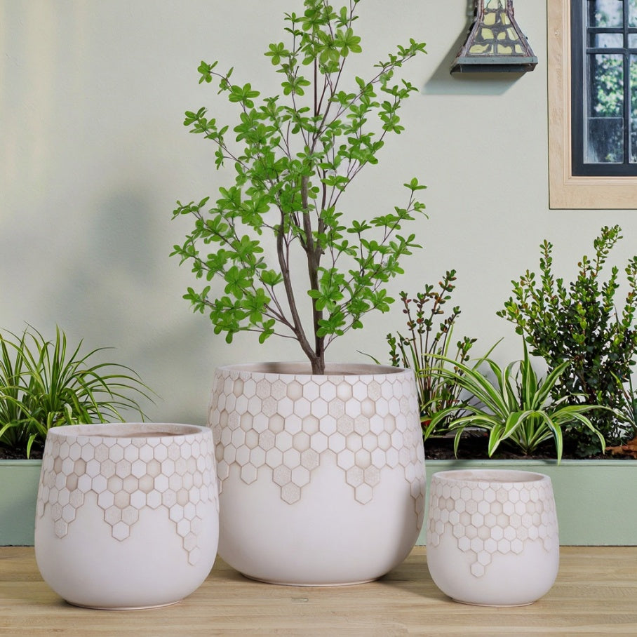 Ribbed concrete planters in multiple sizes for indoor and outdoor plant displays with modern textured decorative design.