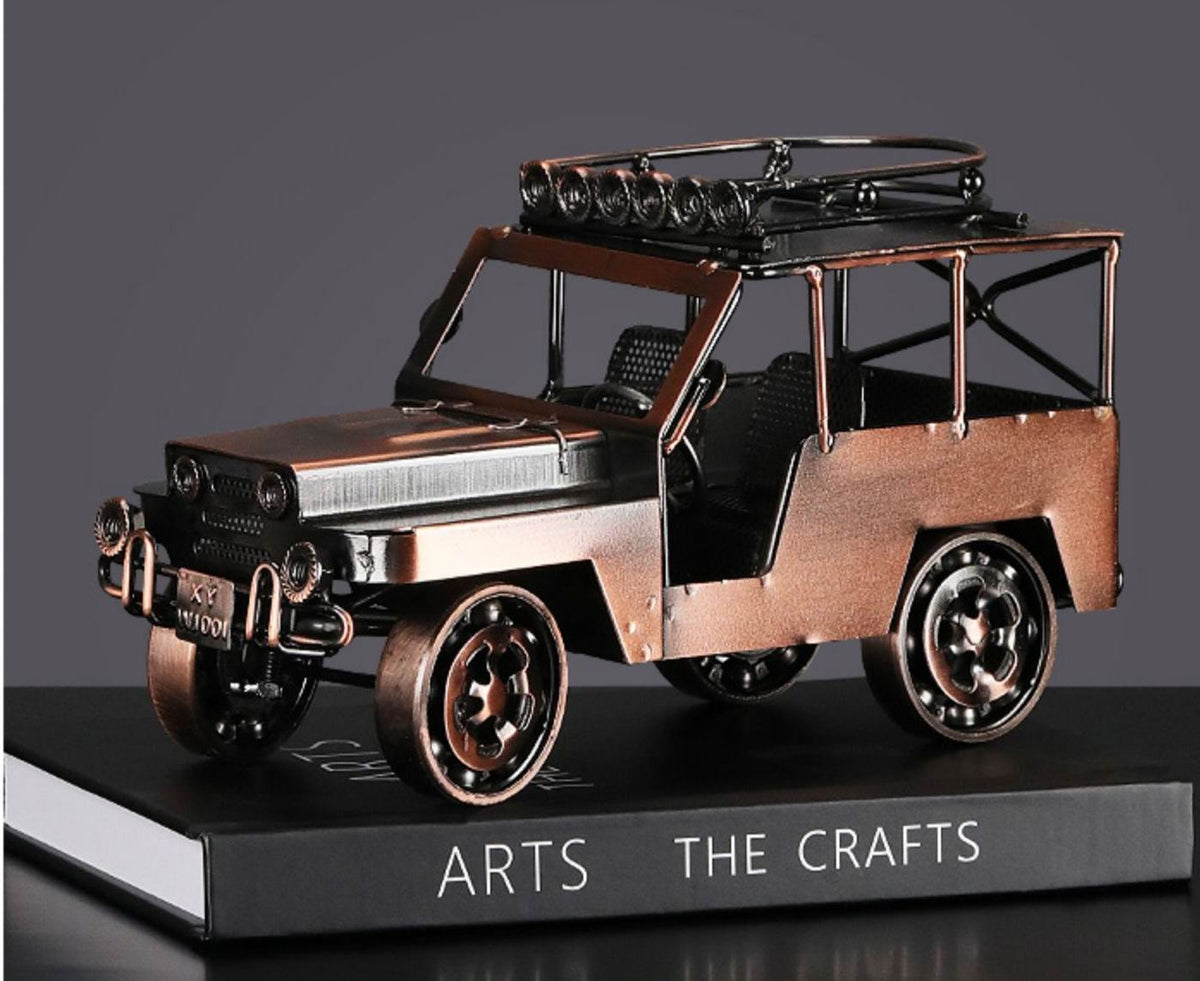 Vintage antique metal car model displayed on a desk or shelf as classic home decor.