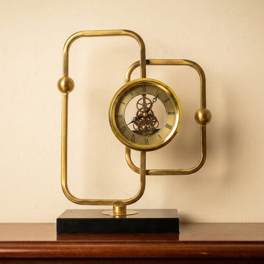 Gemelli Collections modern gold brass geometric skeleton desktop clock with black base and visible gear