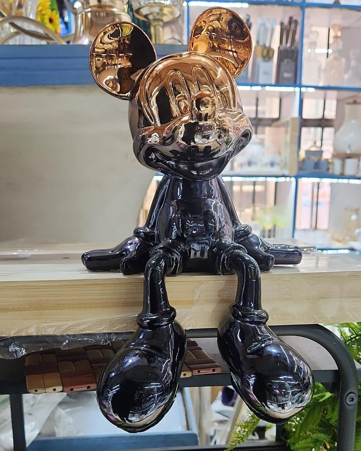 Gemelli Collections chrome black sitting mouse character statue with metallic gold ears, reflective finish, and dangling legs for modern luxury home and office décor.