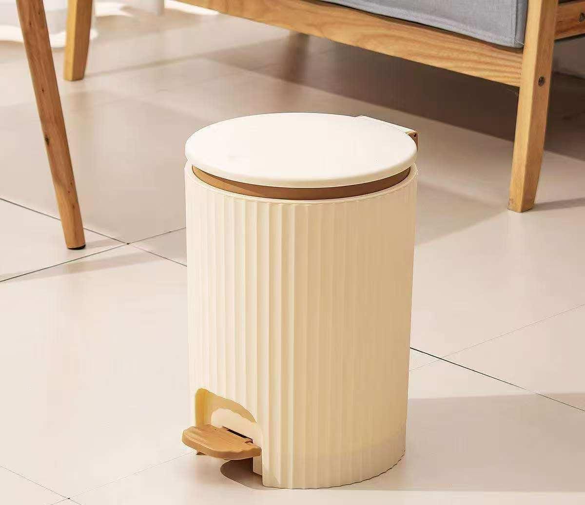 Foot pedal trash can made from durable hard plastic available in grey and beige for hygienic household and office waste disposal.