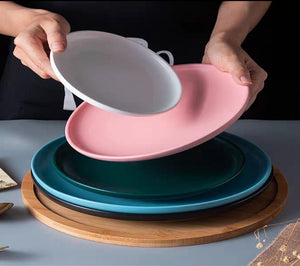 Round Nordic style ceramic dinner plates available in small and large sizes with matte and glossy finishes in white pink cream white black blue and green microwave-safe tableware.