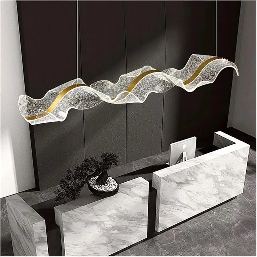 Modern wave-shaped acrylic chandelier with internal gold LED strip creating a glowing sculptural ribbon light effect.
