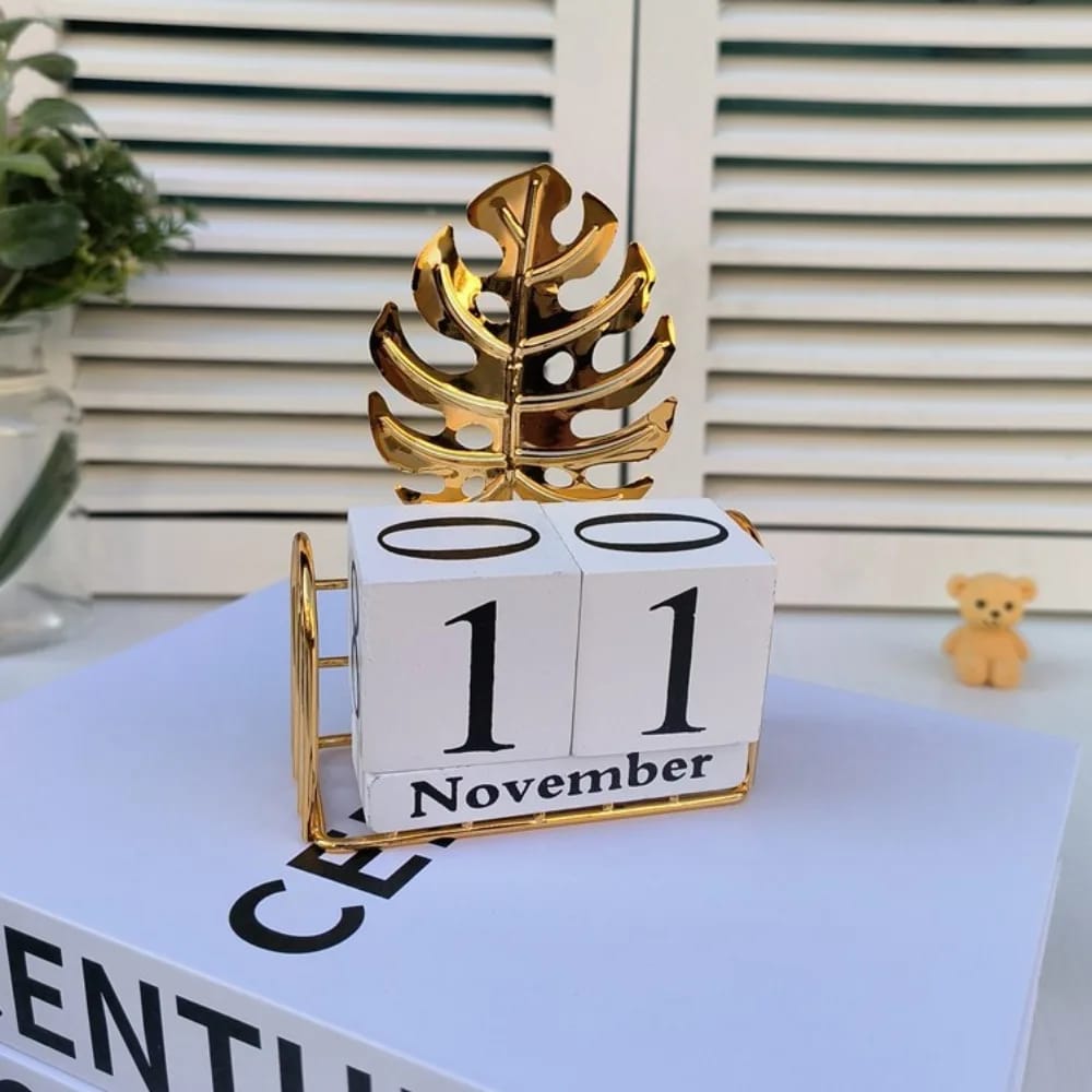 Monstera leaf wooden block perpetual desk calendar with gold metal leaf accent and wire frame base, approximately 20 to 22cm tall for office and home desk décor