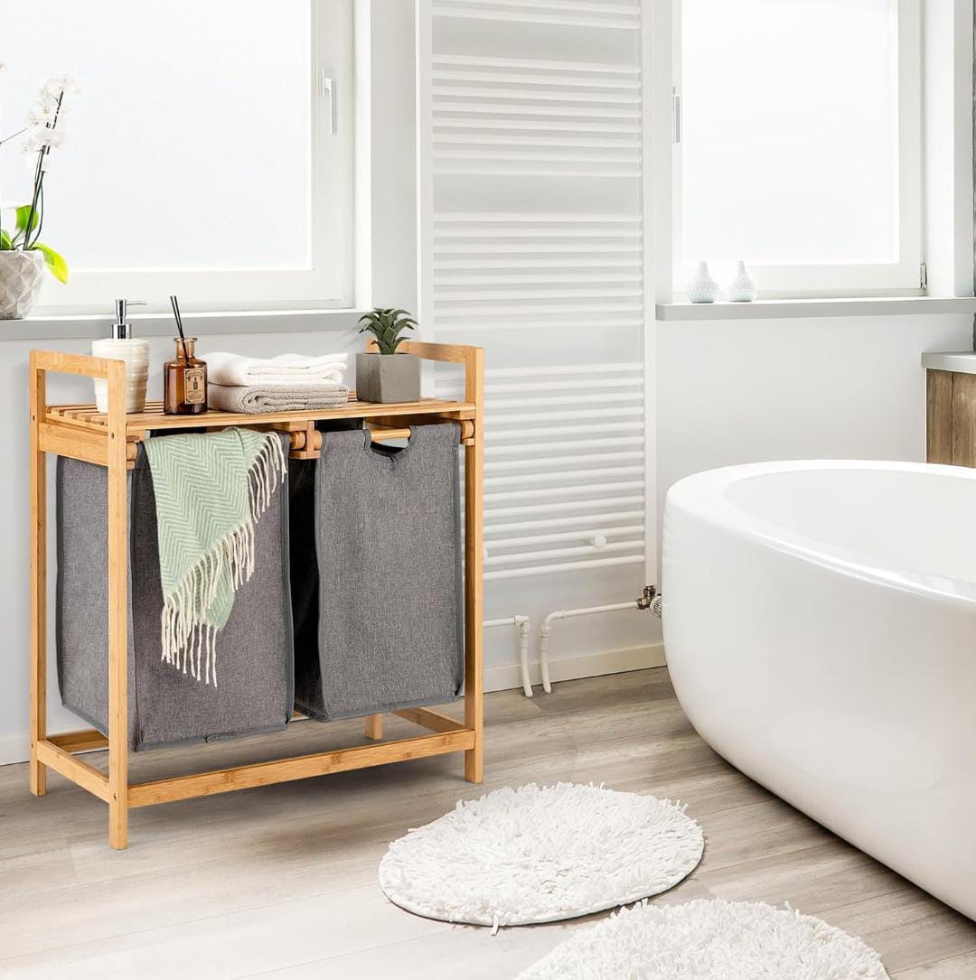 Bamboo twin partition laundry organizer with pullout bags and storage shelf in bathroom
