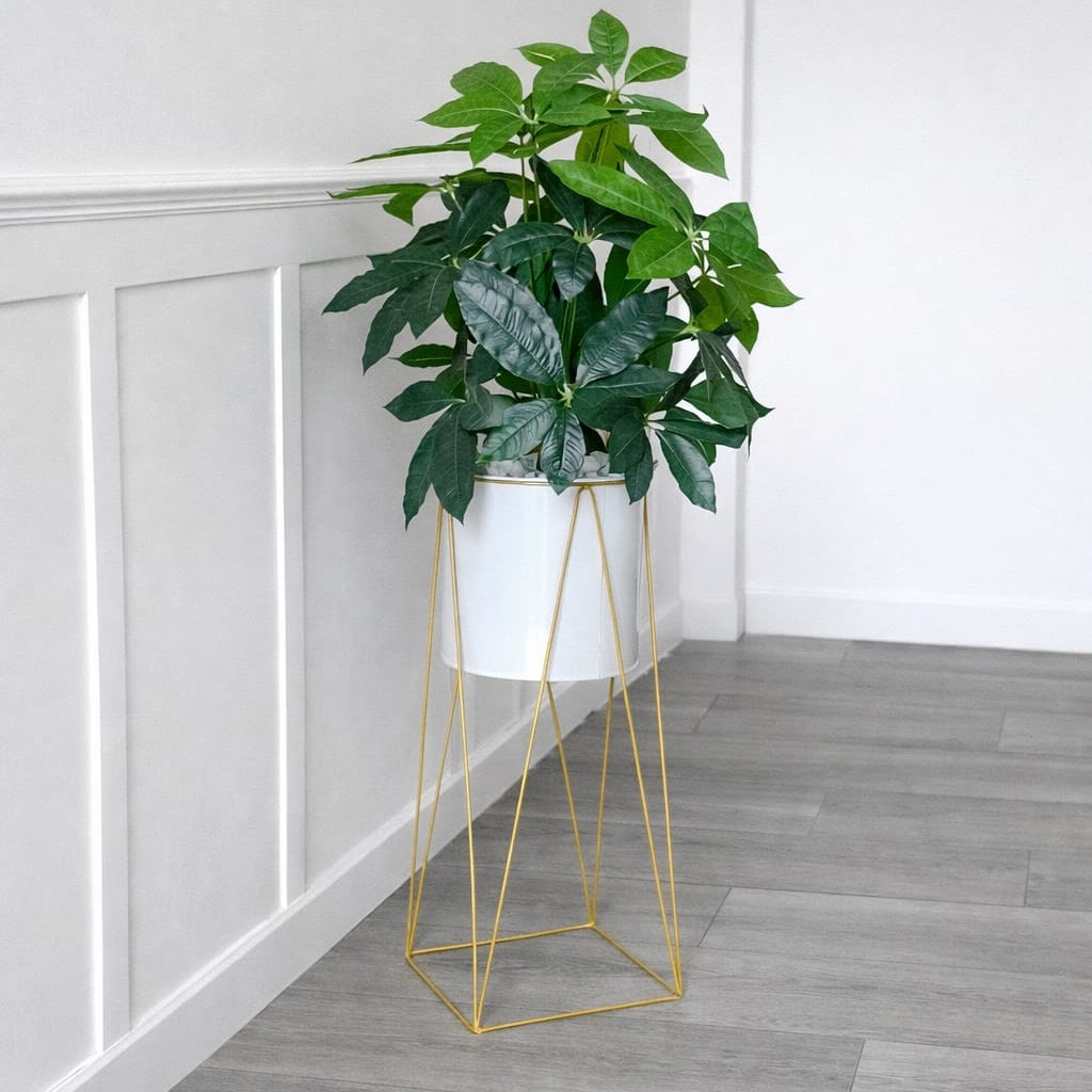 Metallic stand vase with plant and pebbles