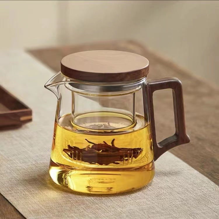High borosilicate glass teapot with walnut handle, integrated filter, and 550ml capacity for brewing and serving tea and herbal infusions