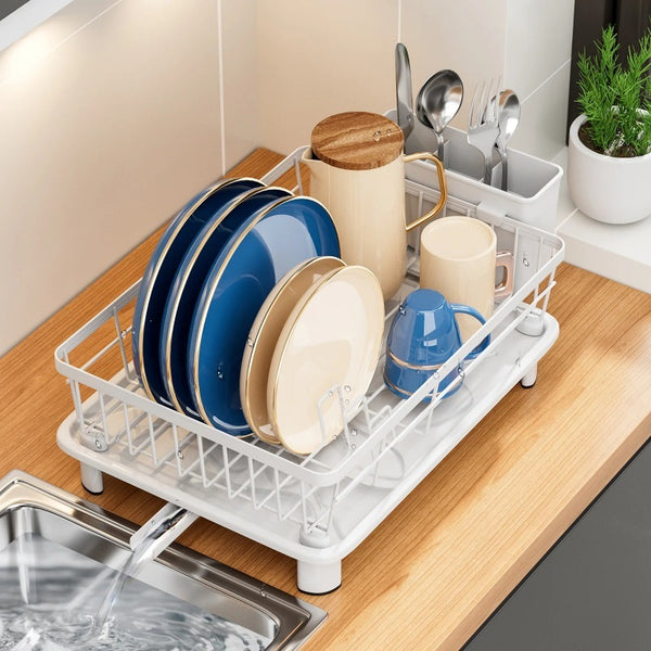 Countertop dish drying rack with white-coated metal frame, removable utensil holder, dedicated dish slots, and integrated drainage spout for organised kitchen drying and storage