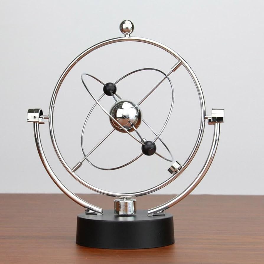 Newton pendulum desk decor with metal balance balls demonstrating motion and physics on an office desk.