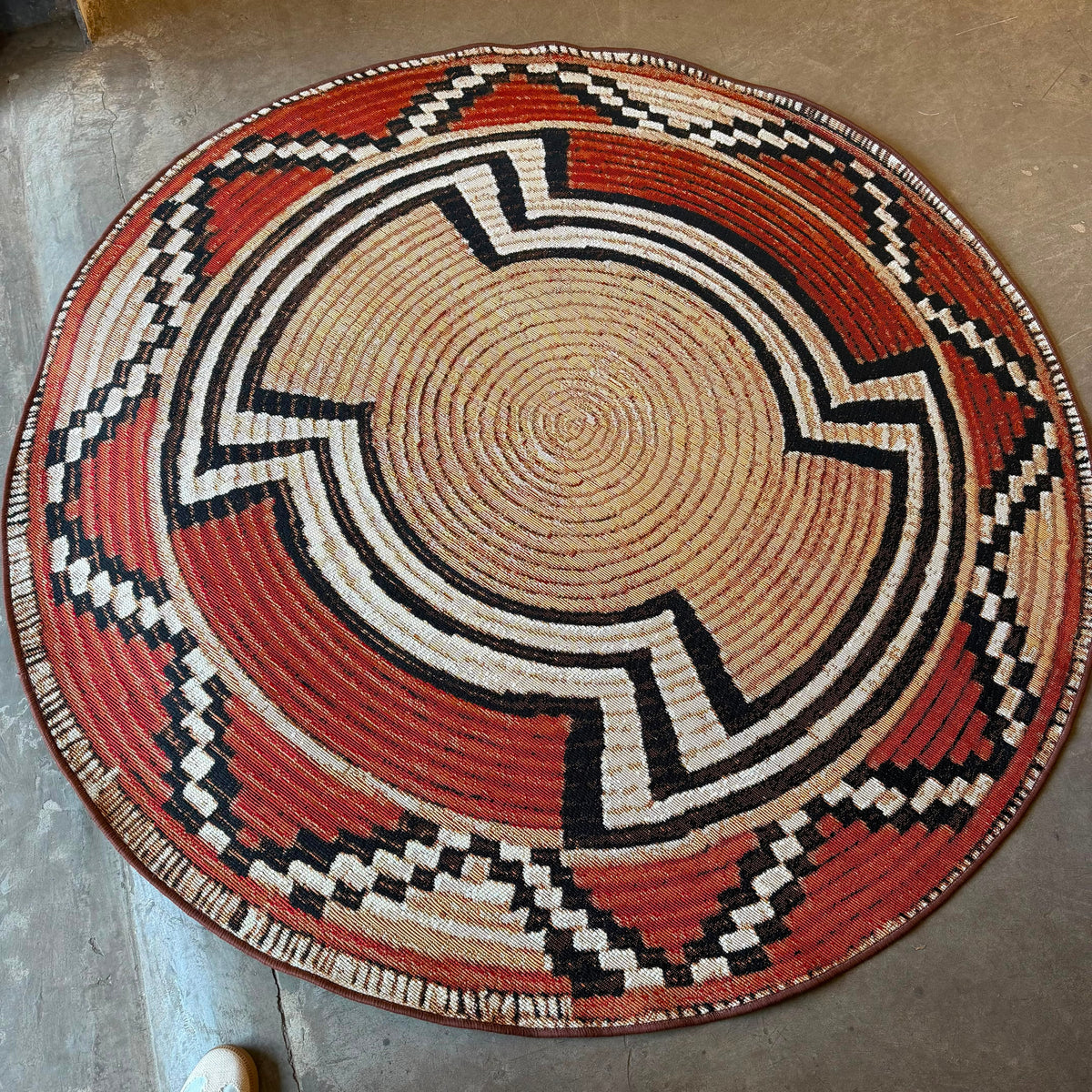 
Oriental Weavers Isla round tribal basket weave rug in terracotta, beige, black, and cream for indoor and outdoor spaces.