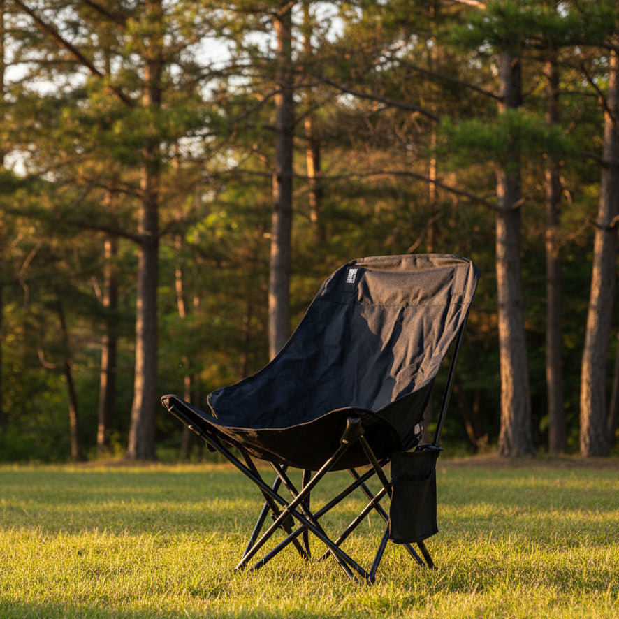 Gemelli Collections foldable low-back camping chair FC 107 with black fabric seat, side storage pocket, non-slip feet, and foldable metal X-frame.