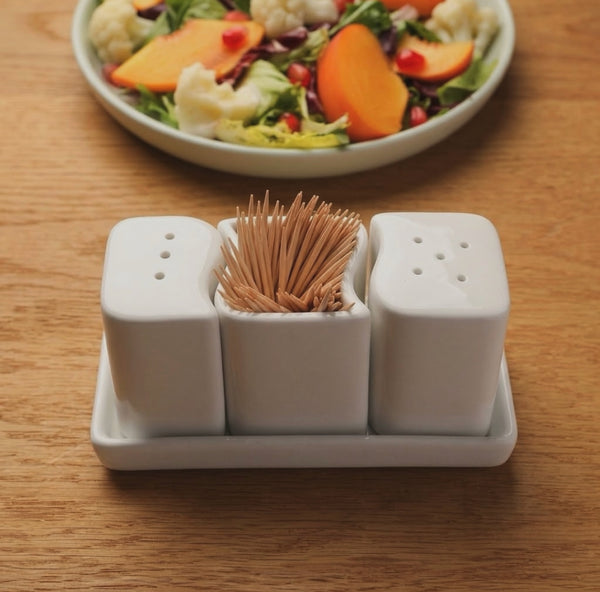 Ceramic salt shaker set with matching tray for organized kitchen and dining table use.