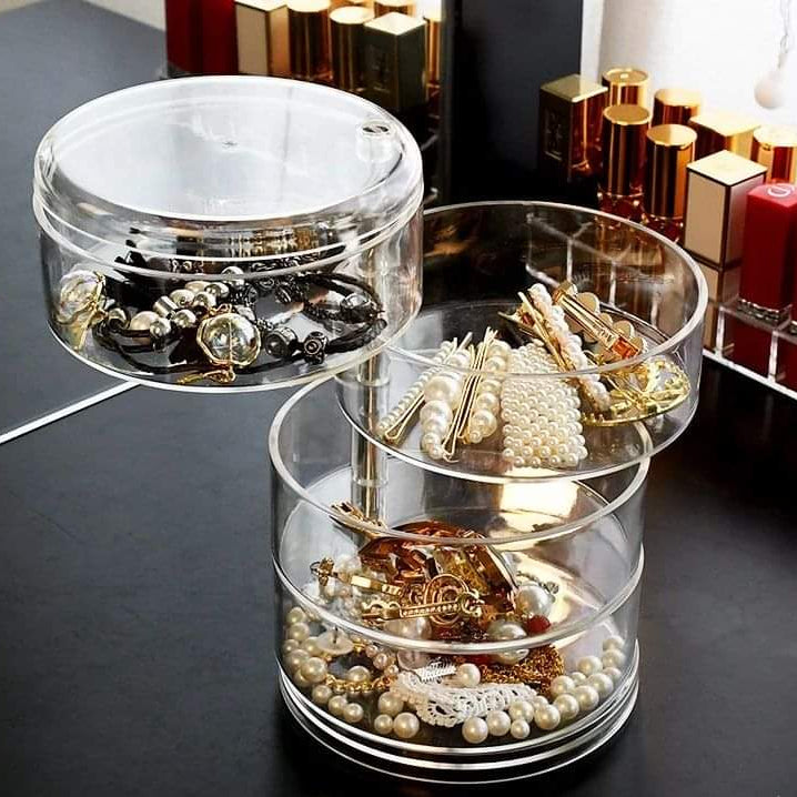 Clear acrylic jewelry organizer with multiple compartments for storing rings, earrings, and necklaces